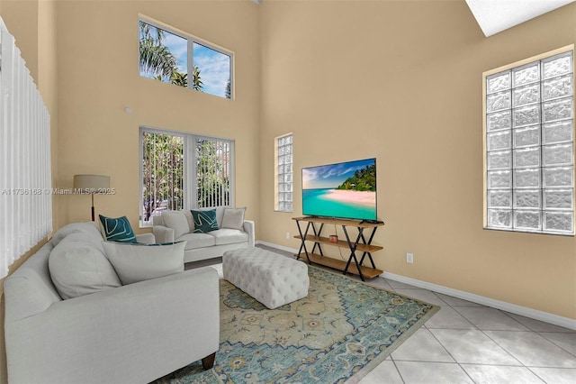 living room with a high ceiling and light tile patterned floors