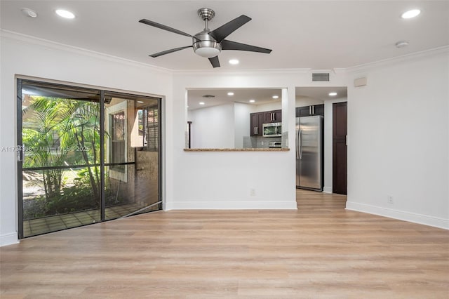 unfurnished living room with crown molding and light hardwood / wood-style floors