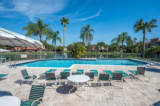 view of pool with a patio area and a water view