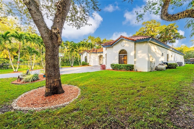 mediterranean / spanish home with a front lawn