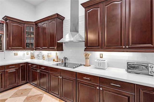 kitchen featuring black electric stovetop, wall chimney range hood, and backsplash