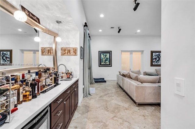 interior space featuring pendant lighting, sink, and dark brown cabinets