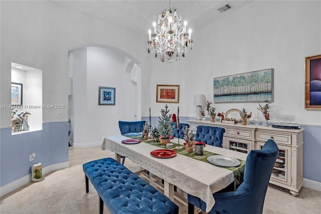 dining space featuring a notable chandelier and a high ceiling