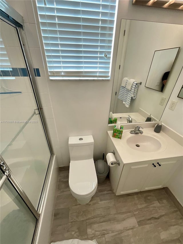 full bathroom featuring shower / bath combination with glass door, toilet, and sink