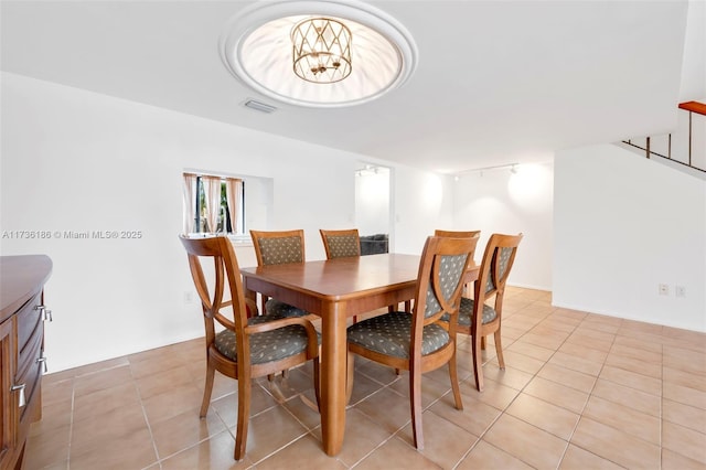 tiled dining area featuring track lighting