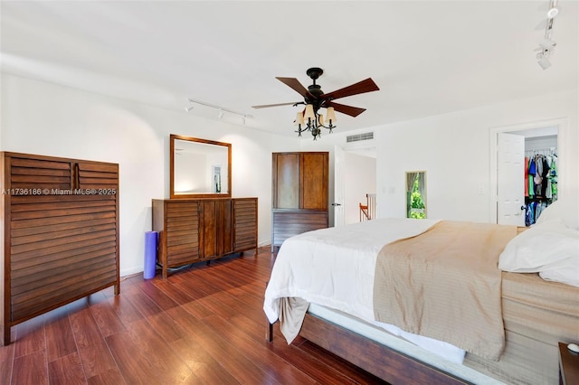 bedroom with rail lighting, dark hardwood / wood-style floors, and ceiling fan