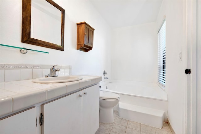 bathroom featuring vanity, a bathtub, tile patterned floors, and toilet