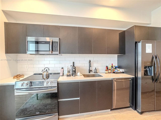 kitchen featuring appliances with stainless steel finishes, sink, and backsplash