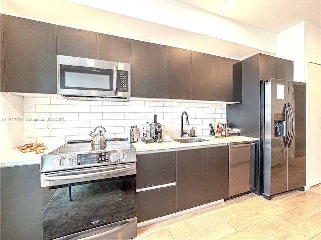 kitchen with tasteful backsplash, appliances with stainless steel finishes, sink, and dark brown cabinets