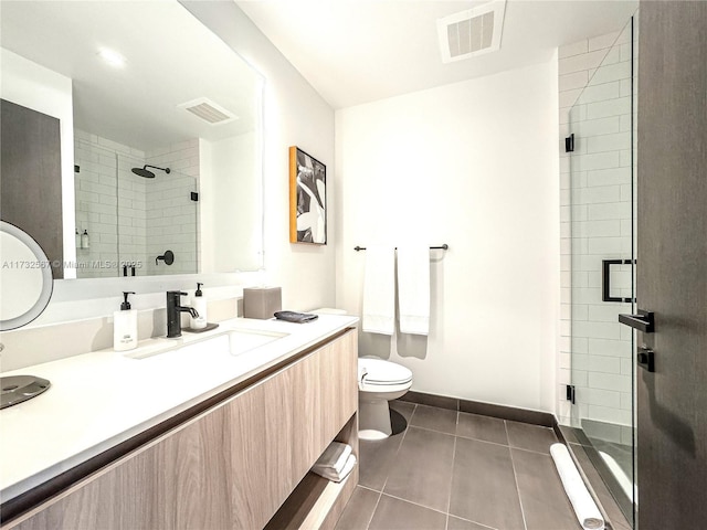 bathroom with vanity, tile patterned floors, toilet, and walk in shower