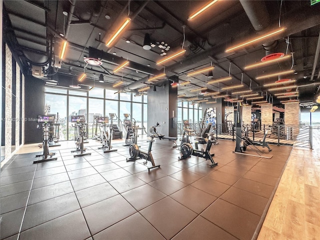 gym featuring expansive windows and wood-type flooring