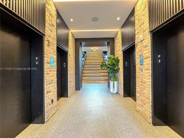 corridor with elevator and brick wall