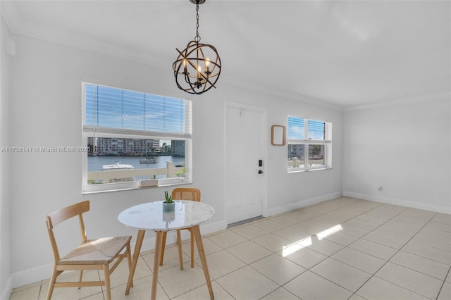 dining space with tile patterned floors, a chandelier, baseboards, and ornamental molding