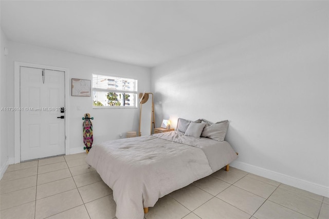 bedroom featuring light tile patterned floors and baseboards