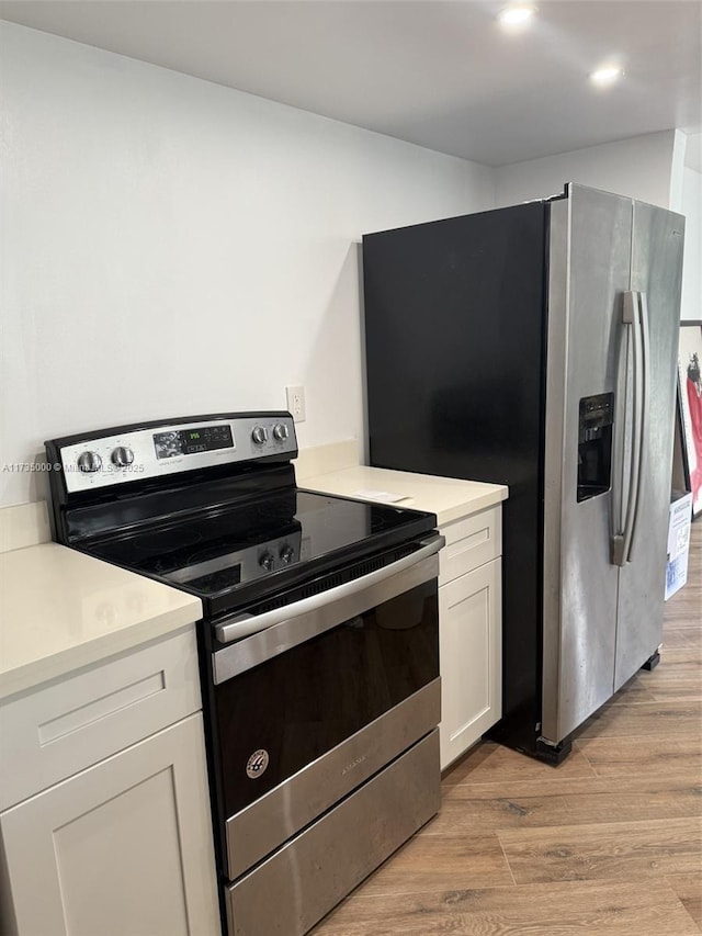 kitchen with white cabinetry, light hardwood / wood-style flooring, and appliances with stainless steel finishes