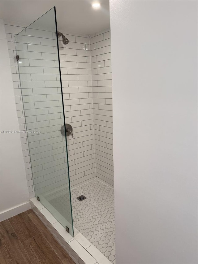 bathroom featuring hardwood / wood-style flooring and tiled shower