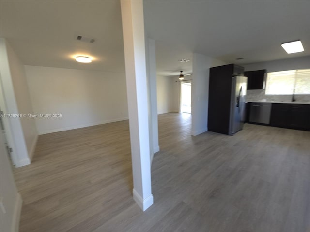 kitchen with decorative backsplash, stainless steel appliances, ceiling fan, and light wood-type flooring