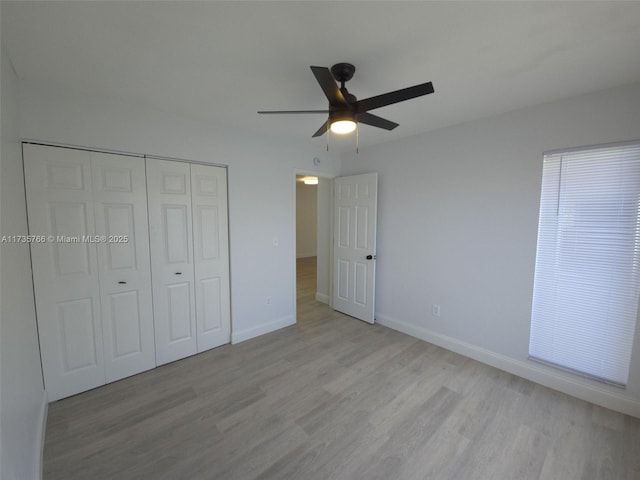 unfurnished bedroom with ceiling fan, light wood-type flooring, and a closet