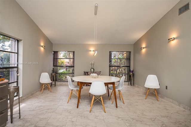 dining space featuring vaulted ceiling and a healthy amount of sunlight