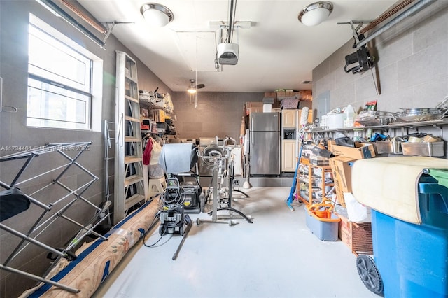 garage with a garage door opener and stainless steel refrigerator