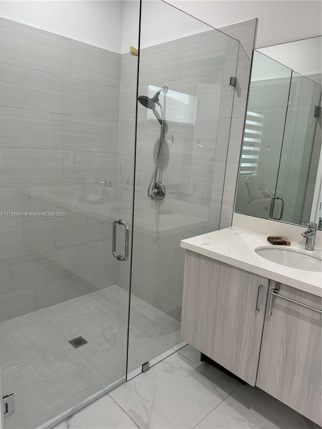 bathroom featuring vanity and a shower with door