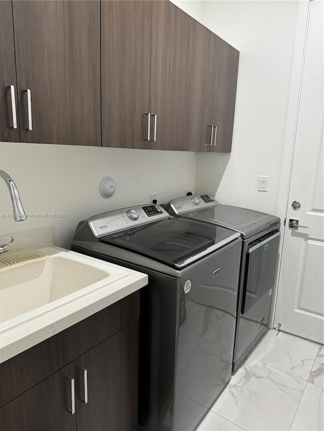 washroom with washer and dryer, sink, and cabinets