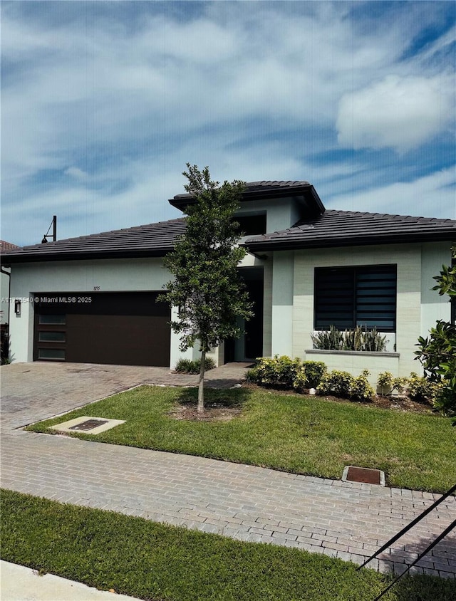 prairie-style home with a garage and a front yard