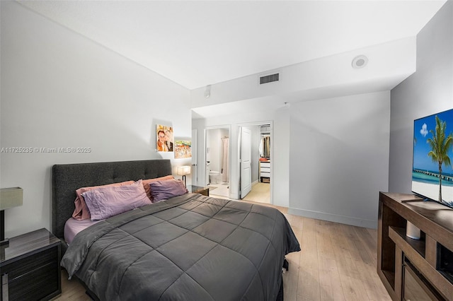 bedroom featuring ensuite bathroom and light wood-type flooring