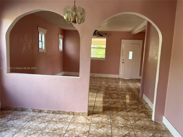 entryway with a chandelier and a textured ceiling