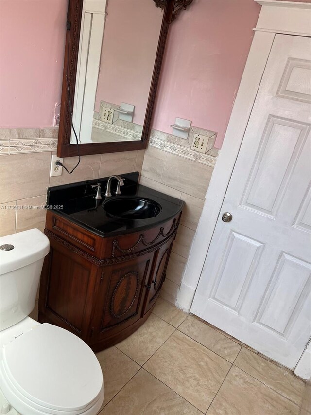 bathroom featuring vanity, tile walls, tile patterned floors, and toilet