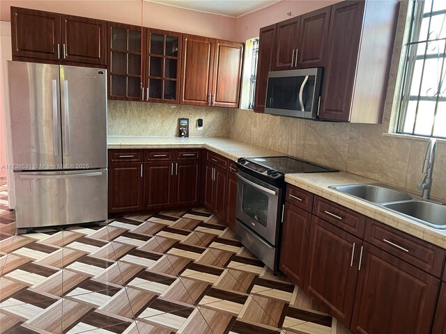 kitchen featuring stainless steel appliances, tasteful backsplash, and sink