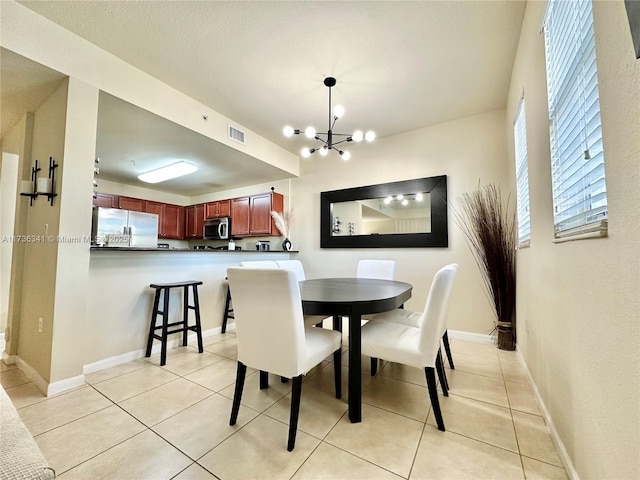 dining area featuring light tile patterned flooring and a chandelier