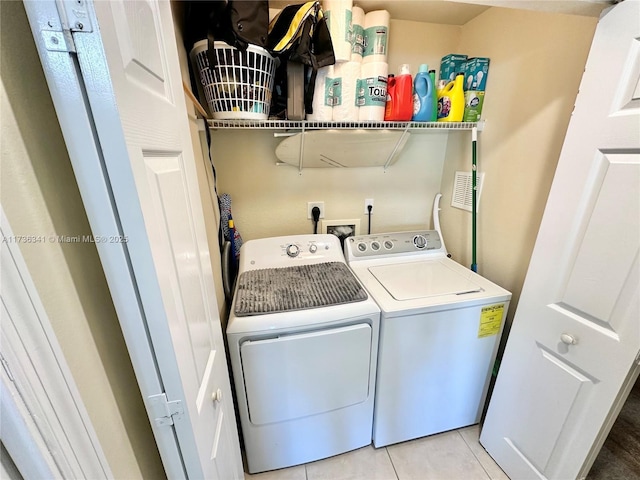 laundry room featuring light tile patterned floors and washer and clothes dryer