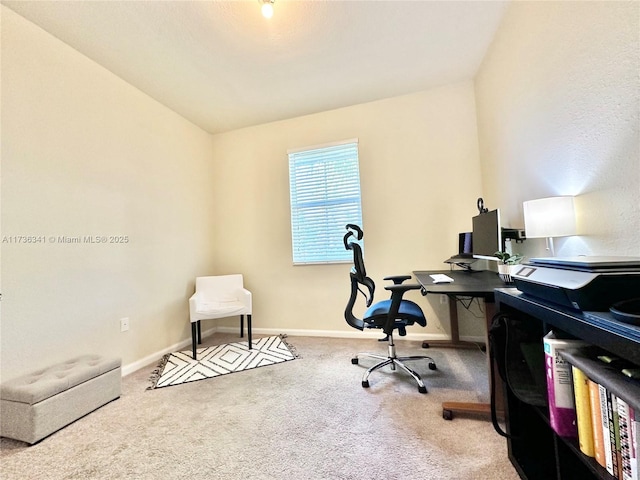 office area with vaulted ceiling and light colored carpet