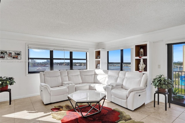 living area with a textured ceiling, ornamental molding, a water view, and light tile patterned flooring