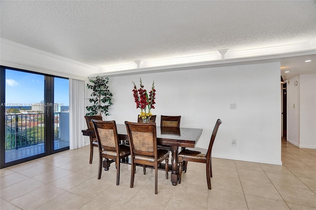 dining room featuring ornamental molding, a city view, a textured ceiling, and light tile patterned floors