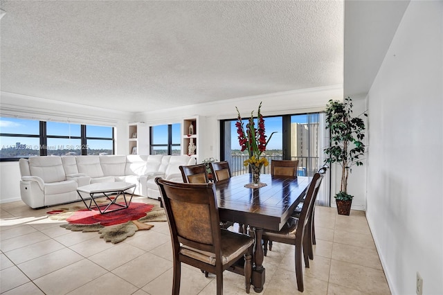 dining space with light tile patterned floors, a wealth of natural light, and a textured ceiling