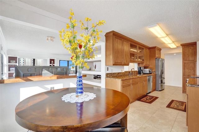 dining space featuring light tile patterned flooring and a textured ceiling