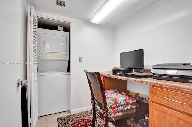 office featuring light tile patterned floors, visible vents, and stacked washer / dryer