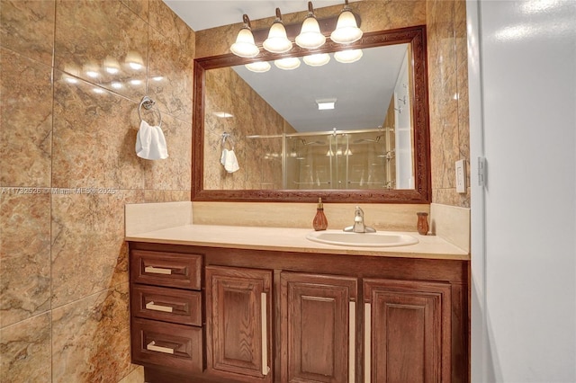 full bathroom with tasteful backsplash, a stall shower, tile walls, and vanity