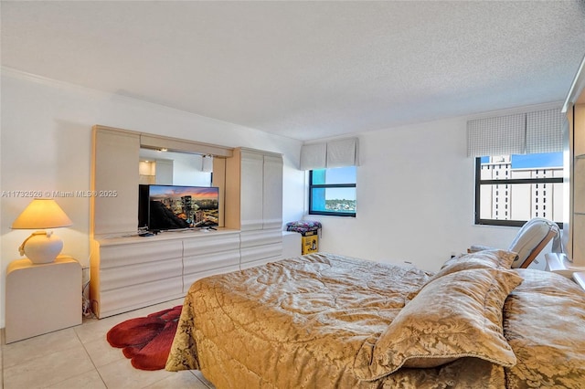 bedroom with a textured ceiling and light tile patterned floors