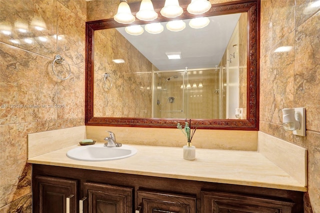 bathroom with vanity, a shower stall, and tile walls