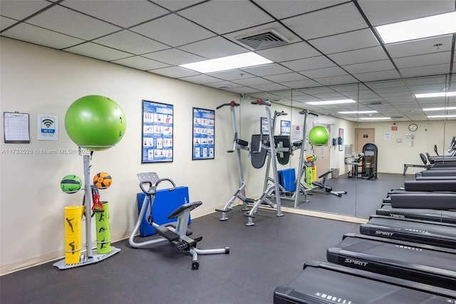 workout area with baseboards, visible vents, and a paneled ceiling