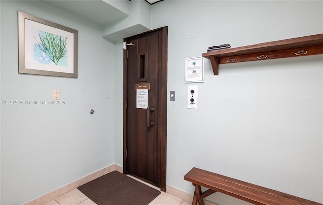 doorway featuring baseboards and light tile patterned floors