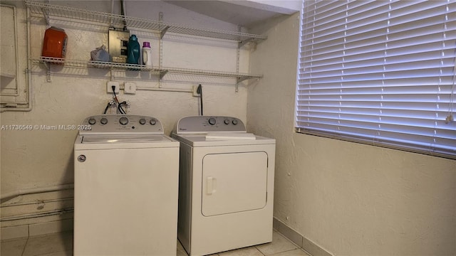 laundry room with washing machine and dryer and light tile patterned floors