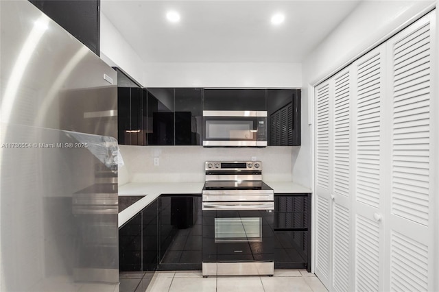 kitchen with recessed lighting, stainless steel appliances, light countertops, and light tile patterned flooring