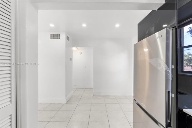 corridor featuring light tile patterned floors, baseboards, visible vents, and recessed lighting