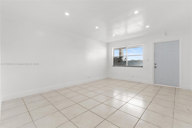 spare room featuring recessed lighting and baseboards