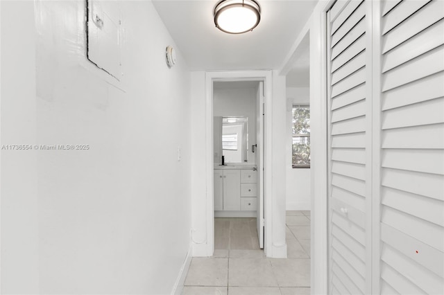 hallway featuring baseboards and light tile patterned floors