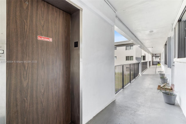 hall with elevator and finished concrete flooring